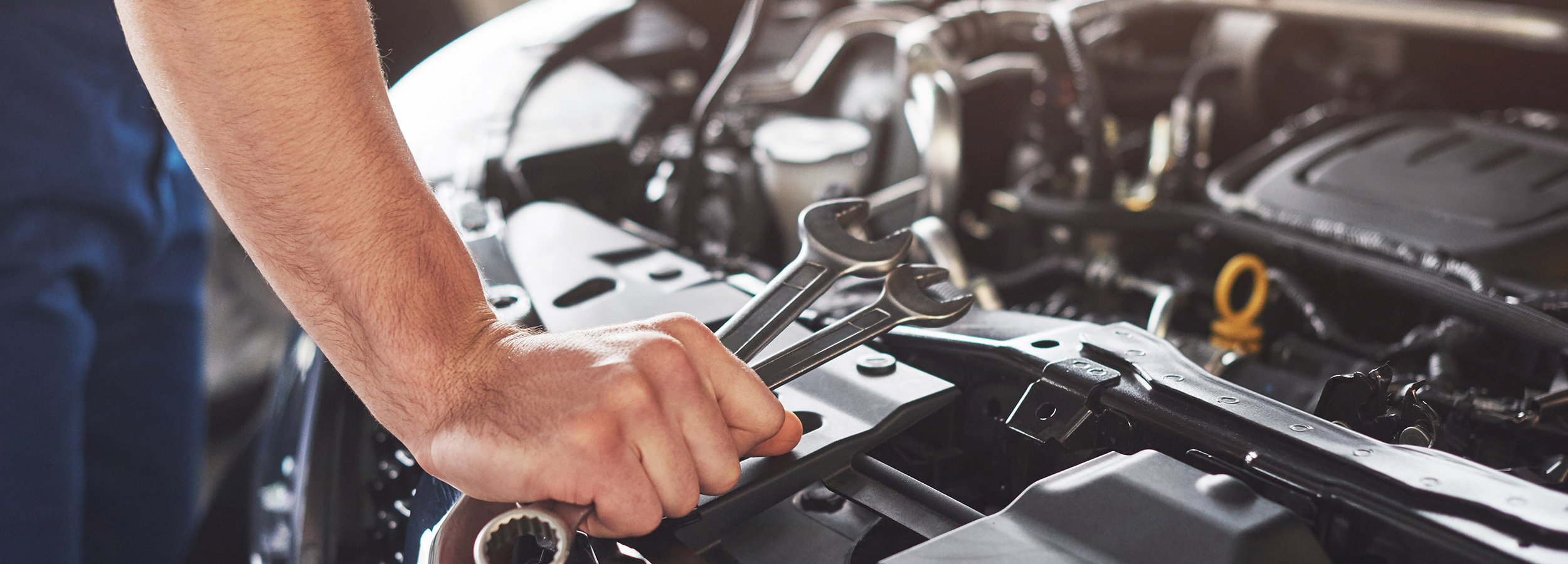 muscular-car-service-worker-repairing-vehicle