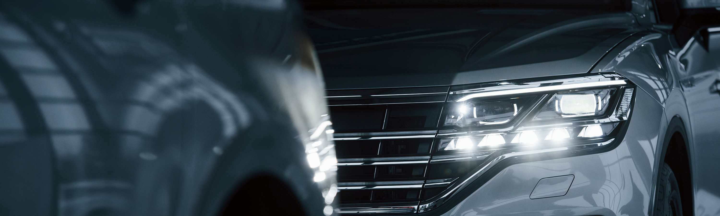 powerful-headlights-particle-view-modern-luxury-cars-parked-indoors-daytime
